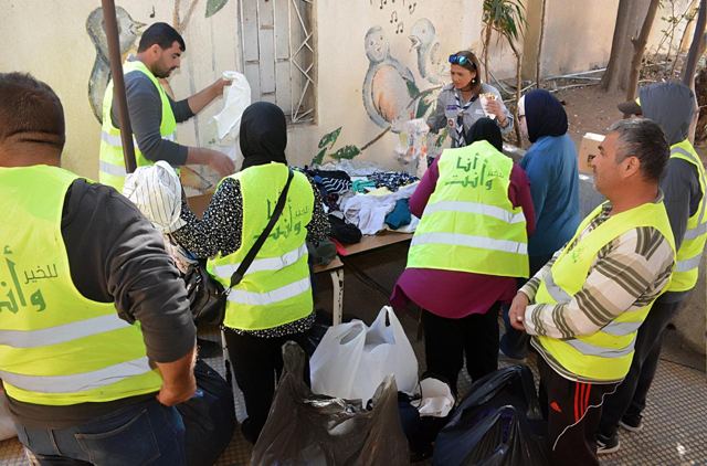 متطوعو الجمعية يفرزون الملابس قبل توزيعها